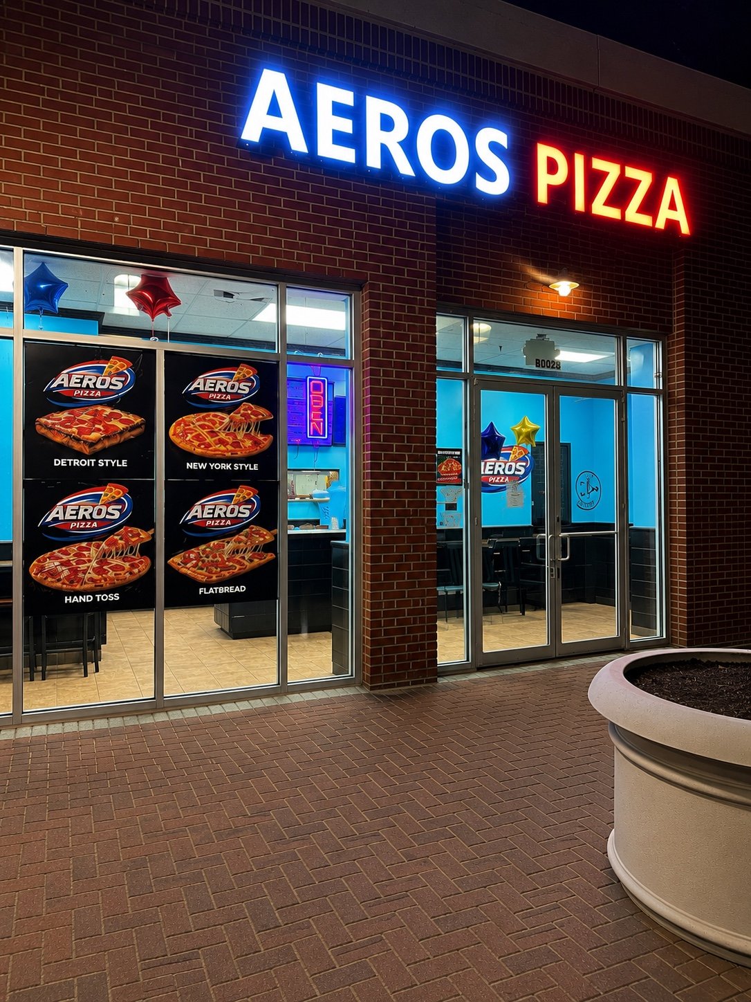 Aeros Pizza storefront at night with illuminated blue and red signage and glass entrance